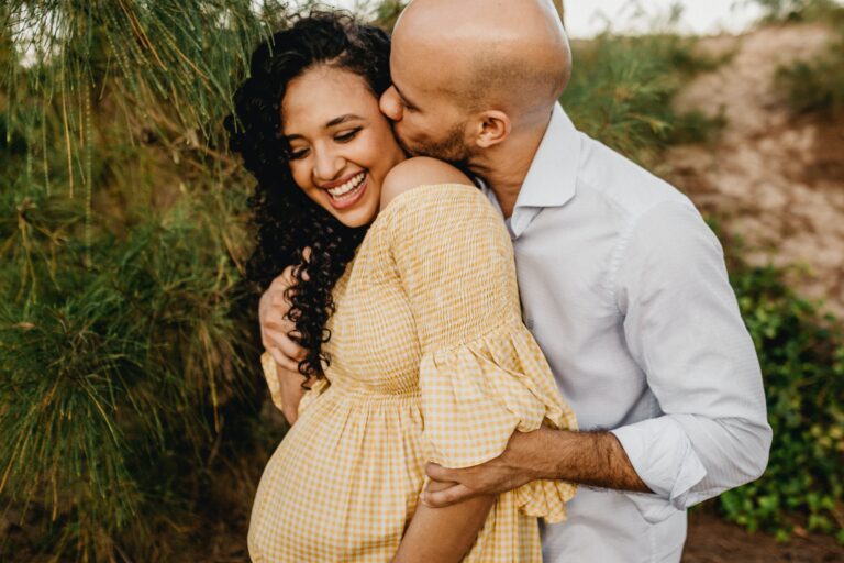 man cuddling pregnant wife