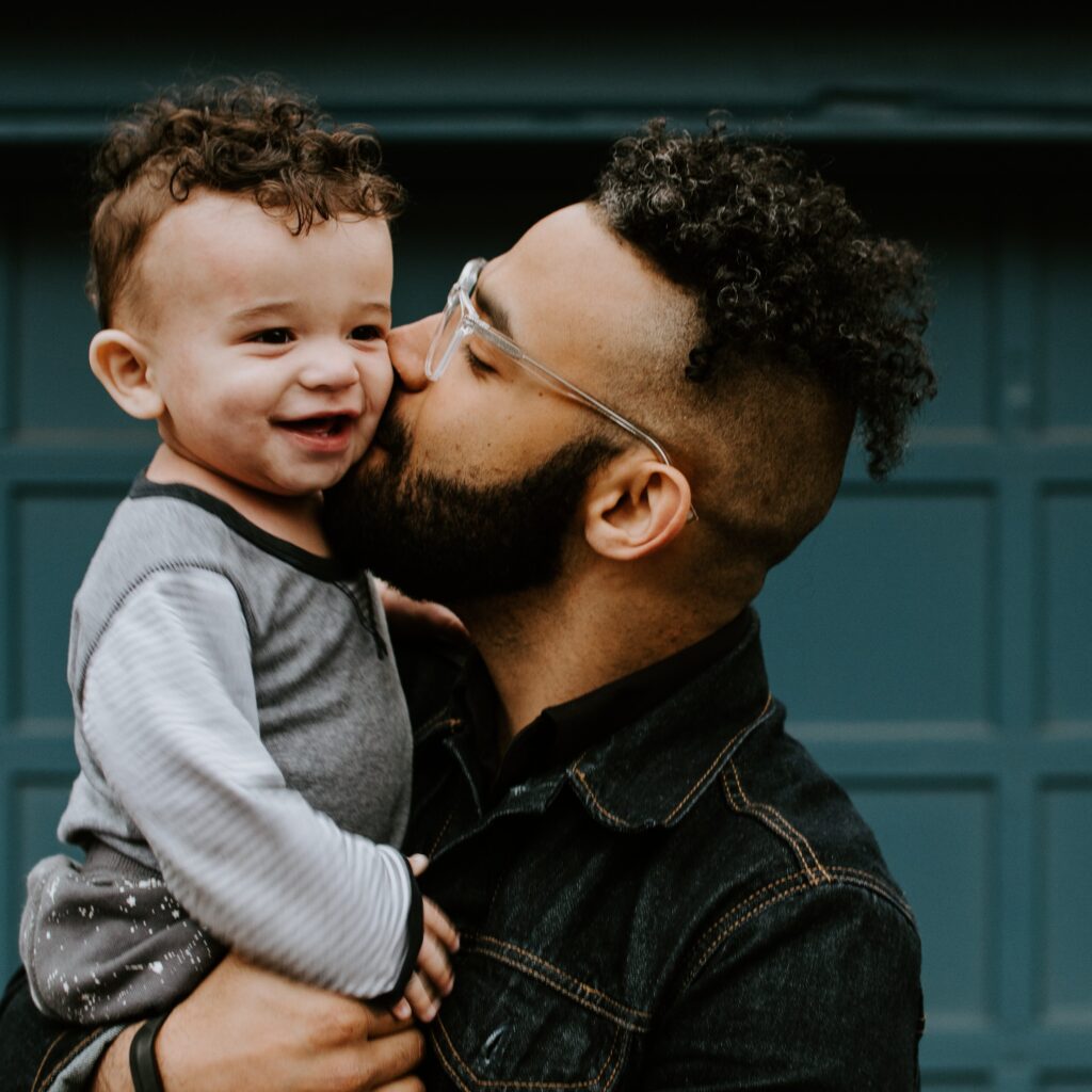 man kissing baby boys cheek